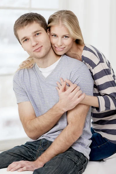 Happy young caucasian couple sitting on couch — 图库照片