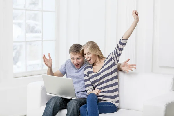 Young caucasian couple sitting on couch — Stock Photo, Image