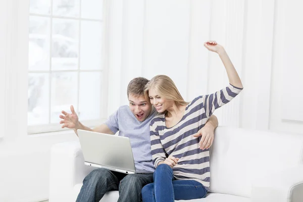 Young caucasian couple sitting on couch — Stock Photo, Image