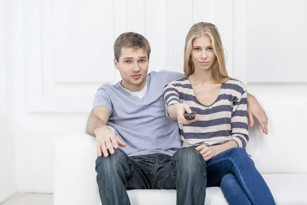 Young caucasian couple sitting on couch — Stock Photo, Image