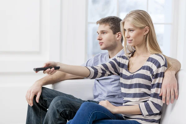 Young caucasian couple sitting on couch — Stock Photo, Image