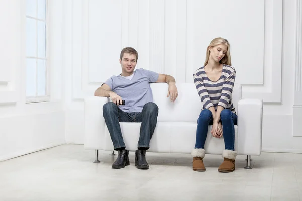 Joven pareja caucásica sentada en el sofá — Foto de Stock