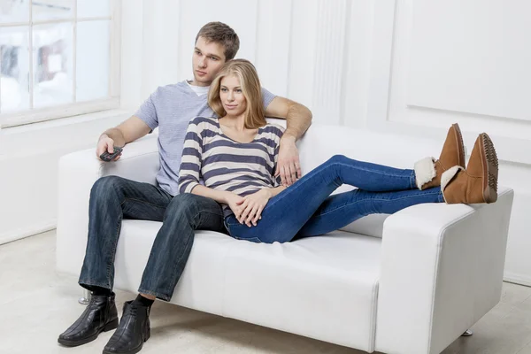 Young caucasian couple sitting on couch — Stock Photo, Image