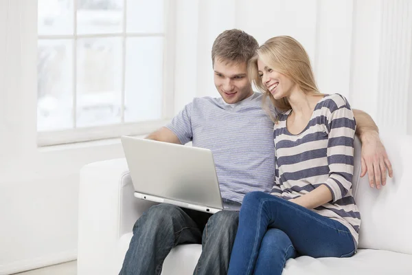 Young caucasian couple sitting on couch — Stock Photo, Image