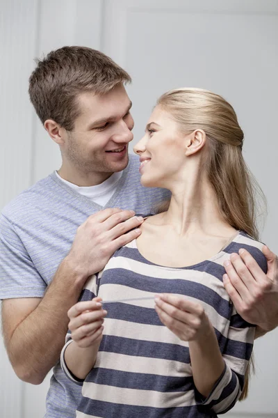 Junges kaukasisches Paar schaut sich Schwangerschaftstest an — Stockfoto