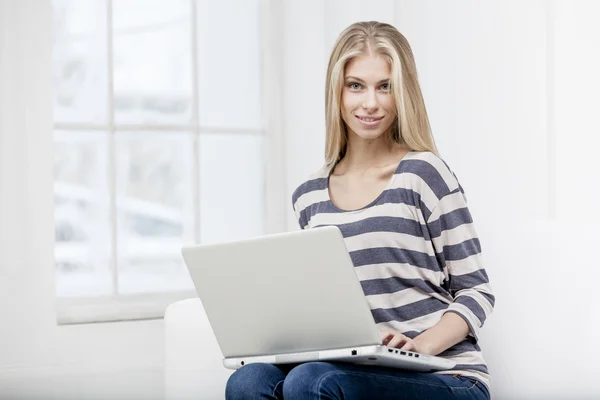 Donna seduta sul divano con laptop — Foto Stock