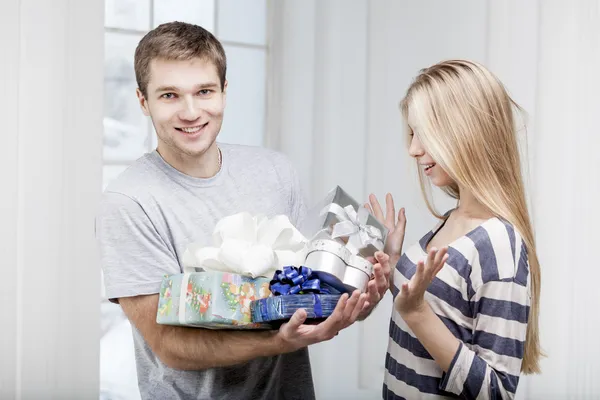 En mann som gir gaver til en ung, vakker kvinne – stockfoto