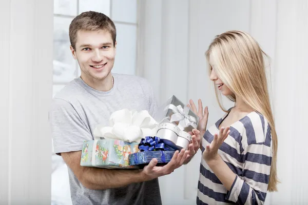 Man ger presenter till en ung vacker kvinna — Stockfoto