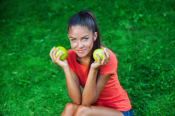 Young beautiful brunette woman holding two apples — Stock Photo, Image