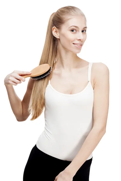 Young blond woman holding comb brushes on white — Stock Photo, Image