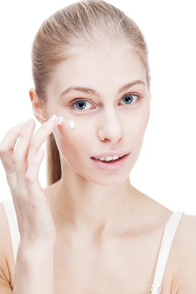 Young blond woman applying facial creme — Stock Photo, Image