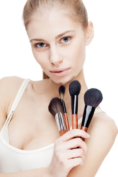 Young blond woman holding cosmetics brushes — Stock Photo, Image