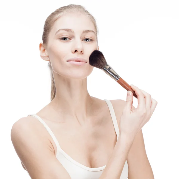 Joven mujer rubia sosteniendo cepillo de cosméticos en blanco — Foto de Stock