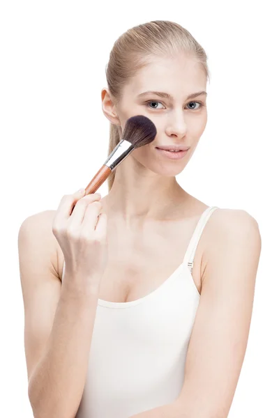 Giovane donna bionda in possesso di cosmetici pennello su bianco — Foto Stock