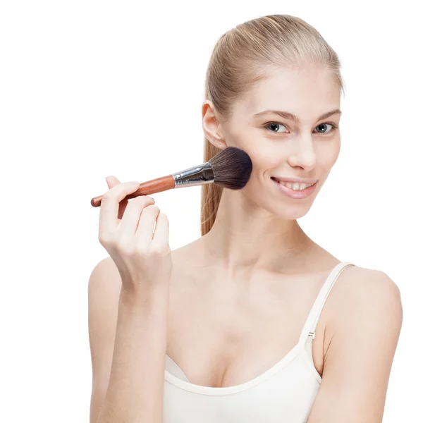 Junge blonde Frau hält Kosmetikpinsel auf weiß — Stockfoto