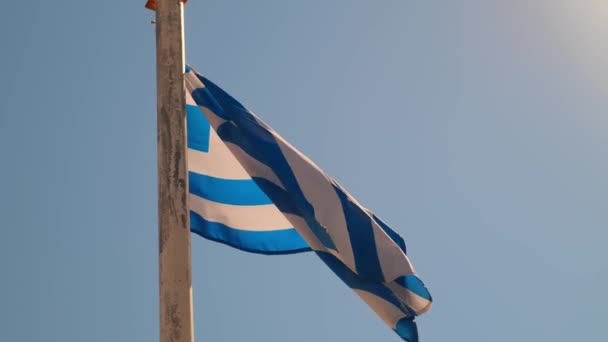 Řecká vlajka na pilíři vlnící se ve větru nad oblohou pozadí — Stock video
