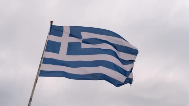 Řecká vlajka na pilíři vlnící se ve větru nad oblohou pozadí — Stock video