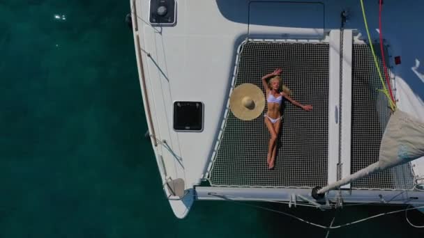 Kvinna i bikini garvning och koppla av på en sommar katamaran segling kryssning — Stockvideo