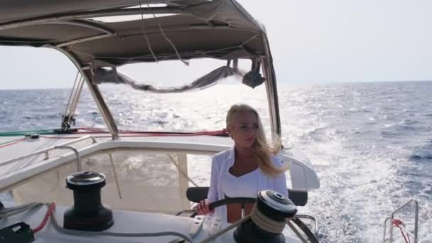 Mulher relaxante em um barco de vela de catamarã de cruzeiro usando vestido de verão branco — Vídeo de Stock