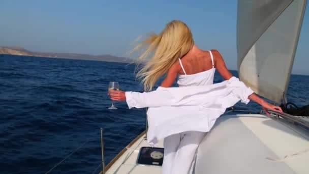 Donna che si rilassa su una barca a vela catamarano crociera indossando abito estivo bianco — Video Stock