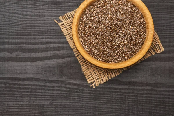Organiczne naturalne nasiona szałwii w drewnianej misce zbliżenie na ciemnym drewnianym tle lub stole — Zdjęcie stockowe