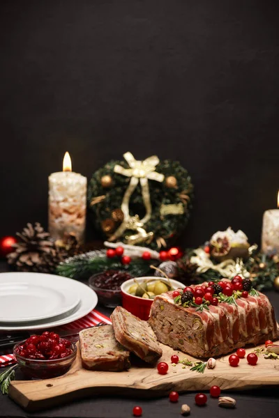 Traditional French terrine covered with bacon on dark wooden background with Christmas decorations — Stock Photo, Image
