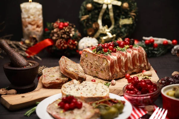 Παραδοσιακό γαλλικό terrine καλυμμένο με μπέικον σε σκούρο ξύλινο φόντο με χριστουγεννιάτικες διακοσμήσεις — Φωτογραφία Αρχείου