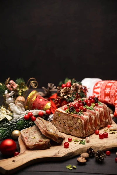 Παραδοσιακό γαλλικό terrine καλυμμένο με μπέικον σε σκούρο ξύλινο φόντο με χριστουγεννιάτικες διακοσμήσεις — Φωτογραφία Αρχείου