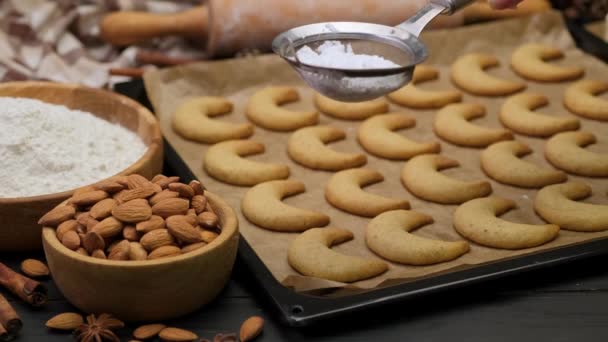 Femme saupoudrer de sucre en poudre sur les biscuits traditionnels allemands ou autrichiens vanillekipferl vanille kipferl — Video