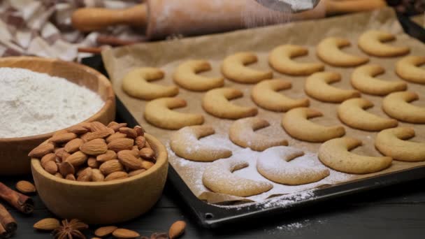 Mulher polvilha açúcar em pó em biscoitos tradicionais de kipferl de baunilha alemã ou austríaca Vanillekipferl — Vídeo de Stock