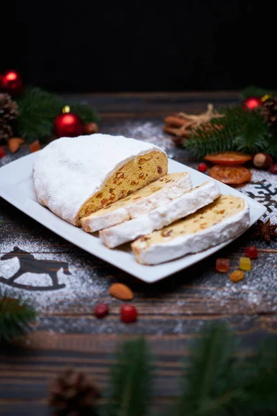 Sliced Traditional Christmas stollen cake with marzipan and dried fruit on wooden background — Stock Photo, Image