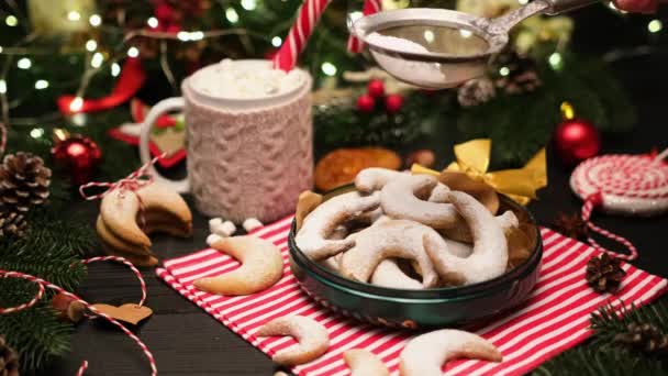 Kvinna strössel socker pulver på traditionella tyska eller österrikiska Vanillekipferl vanilj kipferl cookies — Stockvideo