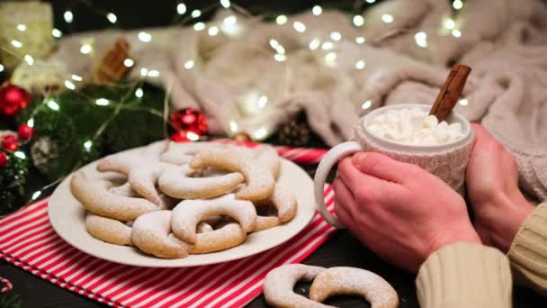 Woman holding cup of cocoa with marshmallow and traditional Vanillekipferl vanilla kipferl cookies — Stock Video