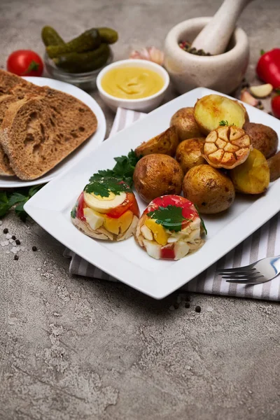 Porção de frango delicioso aspic e batata assada em um prato na mesa de concreto — Fotografia de Stock