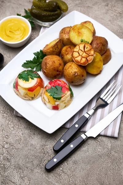 Porção de frango delicioso aspic e batata assada em um prato na mesa de concreto — Fotografia de Stock