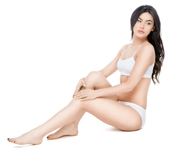 Fitness jovem mulher com um belo corpo sentado no fundo branco — Fotografia de Stock
