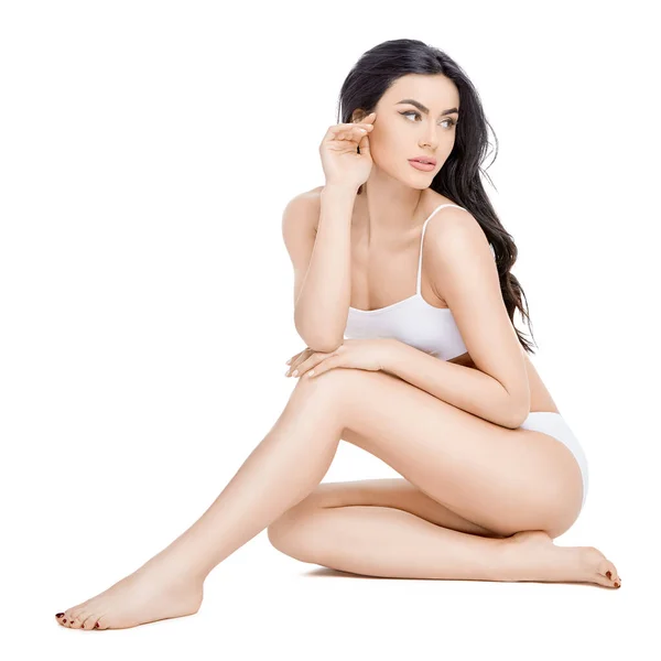 Fitness ung kvinna med en vacker kropp sitter på vit bakgrund — Stockfoto