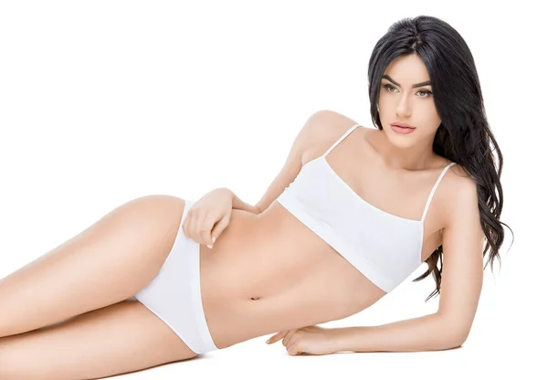 Fitness jonge vrouw met een mooi lichaam zittend op witte achtergrond — Stockfoto