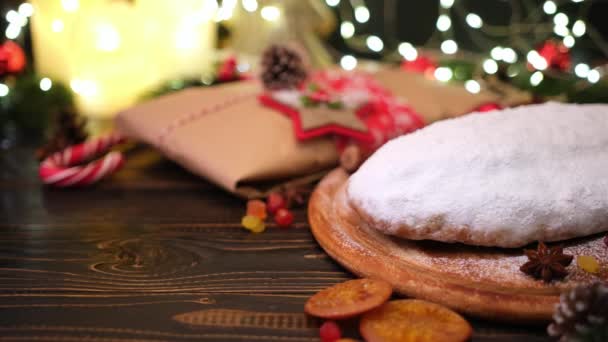 Traditional Christmas stollen cake and New Year decorations on wooden background — Stock Video