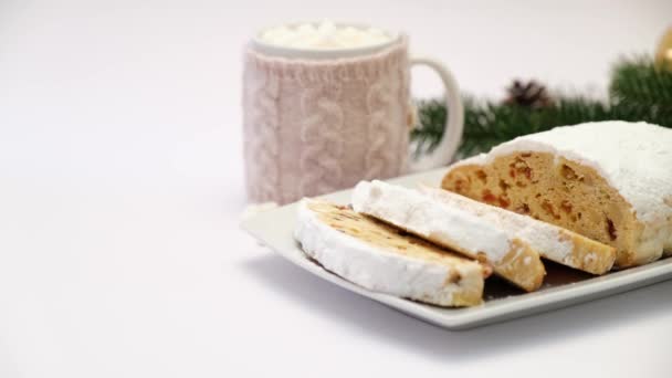 Нарезанный традиционный рождественский торт на керамической тарелке и чашке какао и зефира — стоковое видео