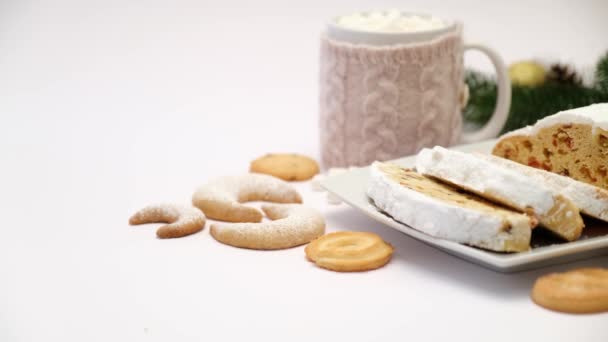 Gesneden traditionele kerst stollen taart op keramische plaat en kopje cacao en marshmallow — Stockvideo