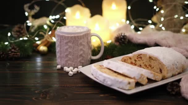 Szeletelt hagyományos karácsonyi stollen torta marcipán és szilveszteri dekorációk fa háttér — Stock videók