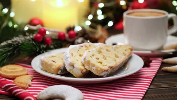 Gesneden traditionele kerst stollen taart met marsepein en Nieuwjaar decoraties op houten achtergrond — Stockvideo