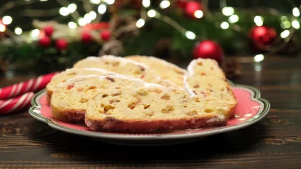 Нарезанный традиционный рождественский торт с марципаном и новогодними украшениями на деревянном фоне — стоковое видео