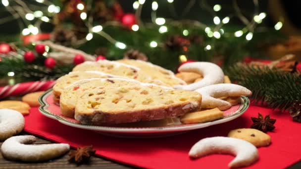 Нарезанный традиционный рождественский торт с марципаном и новогодними украшениями на деревянном фоне — стоковое видео