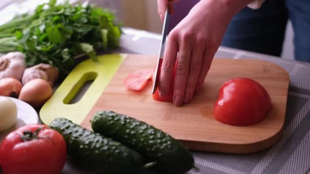 Крупним планом жінка нарізає помідори на дерев'яній дошці - готуючи інгредієнт для їжі — стокове відео