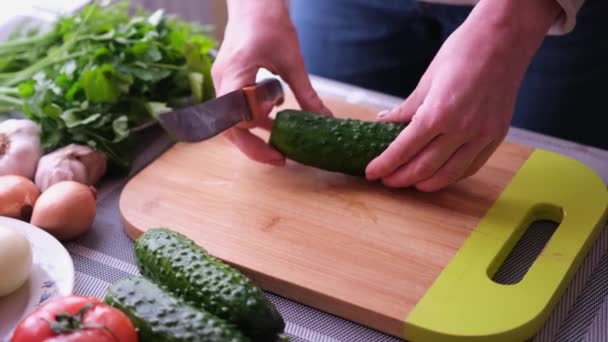 Primer plano de la mujer rebanando pepino en la tabla de cortar de madera - preparando el ingrediente para la comida — Vídeos de Stock