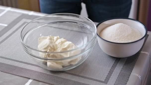 Hacer crema para la torta - mujer pone crema agria en tazón batidor — Vídeo de stock