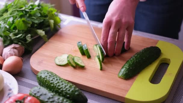 Close-up van de vrouw snijden komkommer op houten snijplank - voorbereiding ingrediënt voor de maaltijd — Stockvideo