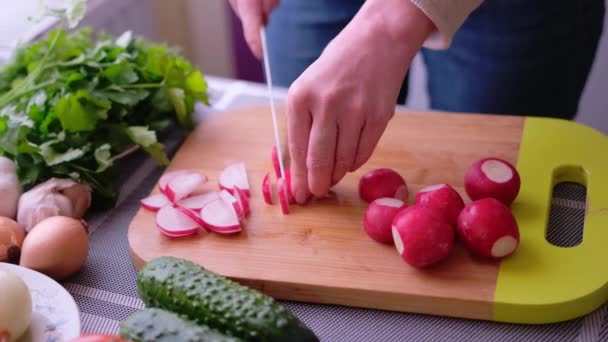 Primo piano della donna affettare ravanello sul tagliere di legno - preparazione ingrediente per pasto — Video Stock